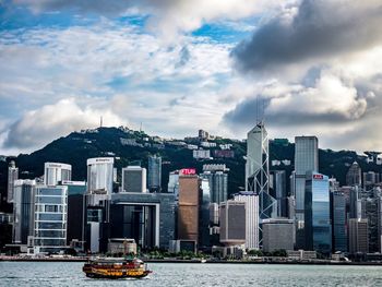 View of buildings in city against cloudy sky