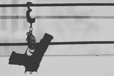 Low angle view of clothespins on rope against wall