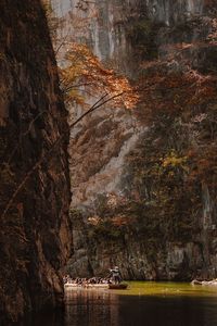 Tourist travelling in boat on river amidst mountains