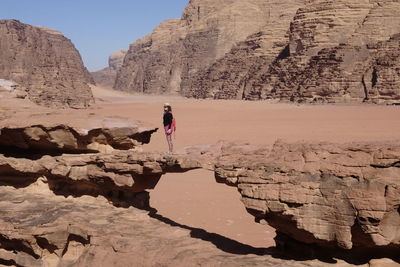 Woman on rock formation in desert
