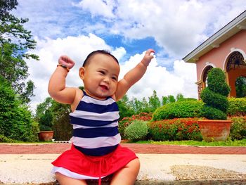 Happy boy in park against sky