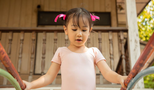 Cute girl standing against house