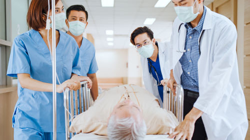 Doctors and nurses with patients in corridor