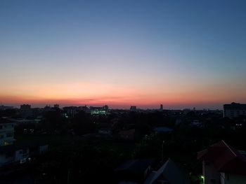 High angle view of silhouette buildings against sky during sunset