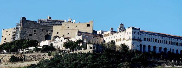 Low angle view of buildings against clear blue sky