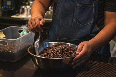 Midsection of barista preparing food in cafe