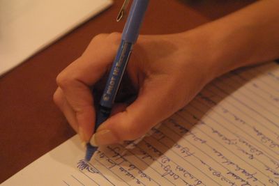 Close-up of hand holding book with text