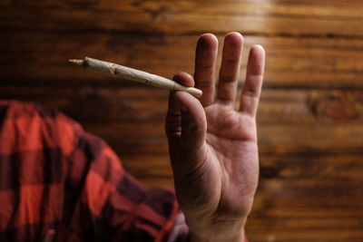 Close-up of hand holding cigarette