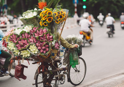 Rear view of man selling bouquets on bicycle at street 