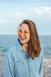 Portrait of young woman standing at beach