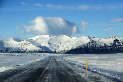 Snowy road with volcanic mountains in wintertime, iceland