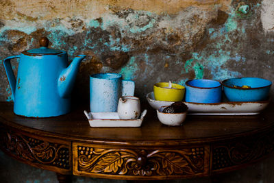 Close-up of crockery on table against wall