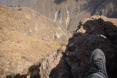 Low section of man standing on cliff