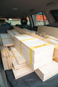 Wooden plywoods stacked and labeled with measurement inside the car.