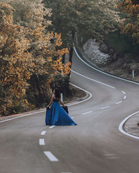 Rear view of woman walking on road