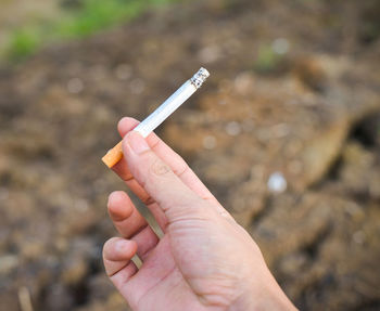 Cropped hand holding cigarette