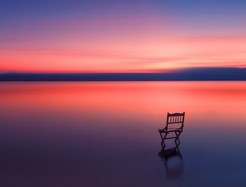 Beautiful scenery lake with long exposure sunset and wooden chair