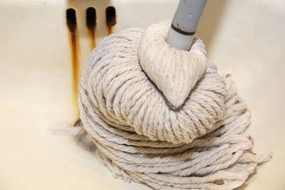 Wringing out a mop in an old sink