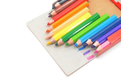 High angle view of colored pencils against white background