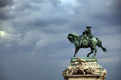 Low angle view of statue of angel against cloudy sky