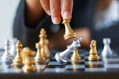 Close-up of human hand playing chess