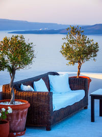 Chairs and tables by swimming pool against sky