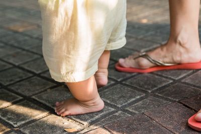 Low section of woman standing on footpath