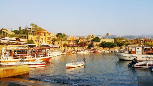 Boats moored in river against clear sky