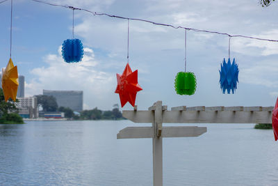 Lanterns hanging by buildings against sky