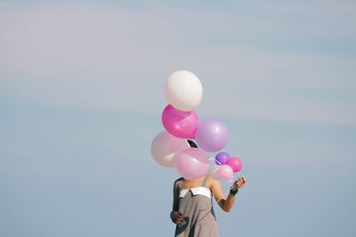 Close-up of multi colored balloons against sky