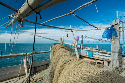 Sailboats on beach against blue sky