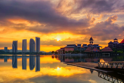 Reflection of buildings in lake at putrajaya during sunrise