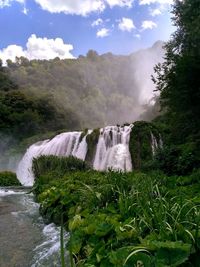 Scenic view of waterfall against sky