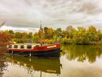 Boat moored in lake against sky