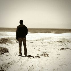 Rear view of people standing on beach