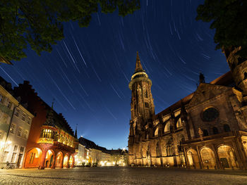 Low angle view of illuminated buildings in city against sky at night