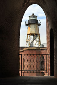 Old tower against sky seen through window