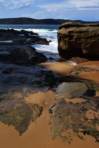 Rocks on beach against sky