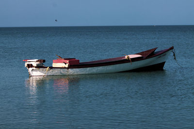 Boat sailing in sea against clear sky