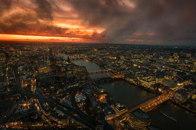 Aerial view of illuminated cityscape against sky during sunset