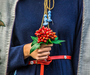 Close-up of man holding fruit and flowers