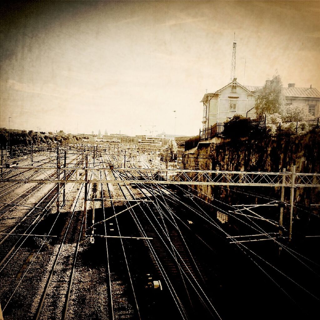 railroad track, transportation, rail transportation, sky, high angle view, public transportation, built structure, diminishing perspective, architecture, the way forward, clear sky, vanishing point, building exterior, railway track, railroad station, outdoors, auto post production filter, landscape, metal, no people