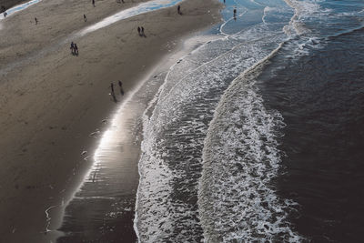 High angle view of silhouette people at beach during sunny day