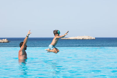 Man playing with son in infinity pool