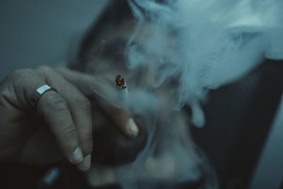 Cropped hand of man smoking