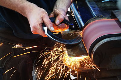 Midsection of man holding fire crackers at night