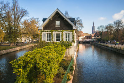 Scenic view of river by buildings against sky in strasbourg, france