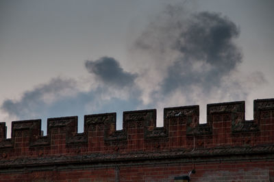 High section of wall against clouds