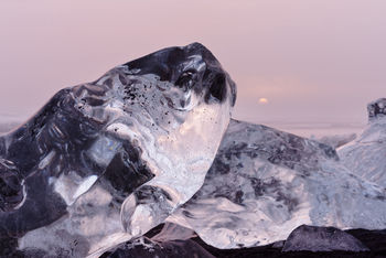 Scenic view of frozen rocks against sky during sunset