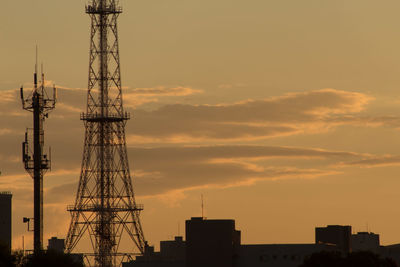 Low angle view of silhouette cranes against sky during sunset